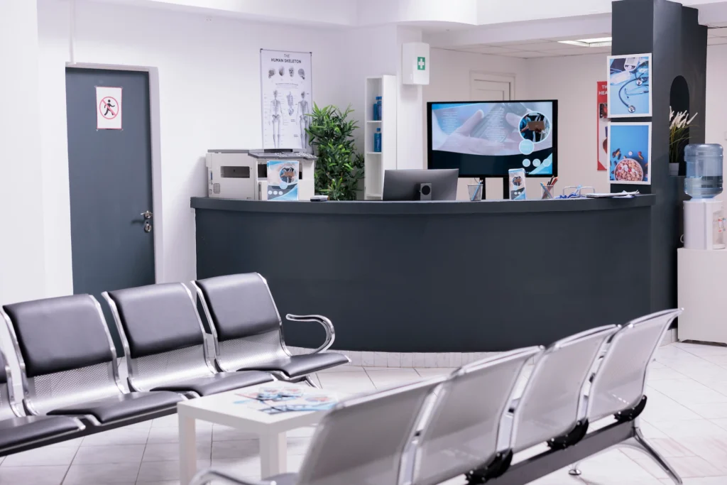 une salle d'attente dans le secteur médical et santé, avec une banque d'accueil et des chaises