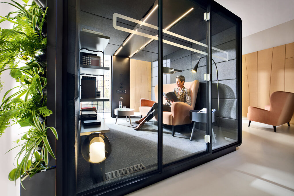une cabine acoustique dans laquelle se trouve l'employée d'une entreprise professionnelle