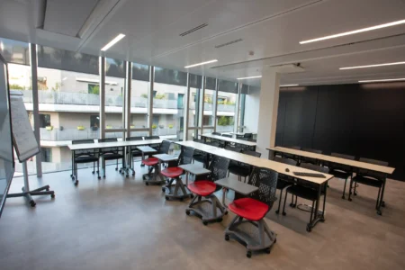 aménagement d'espaces de l'école de commerce em business school normandie, à Paris : cabines acoustiques, fauteuils lounge, tables de travail, bibliothèque, espace coworking, tables ébénisterie, réunion, conférence, espade de vie commune, éclairage acoustique