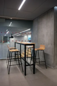 aménagement d'espaces de l'école de commerce em business school normandie, à Paris : cabines acoustiques, fauteuils lounge, tables de travail, bibliothèque, espace coworking, tables ébénisterie, réunion, conférence, espade de vie commune, éclairage acoustique