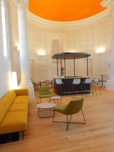 aménagement d'espaces et agencement de mobilier pour le Collegium de Bayeux : table de réunion, chaises empilables, sièges de conférence, canapé lounge, bar central