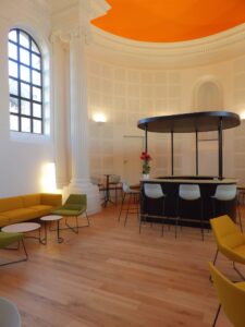 aménagement d'espaces et agencement de mobilier pour le Collegium de Bayeux : table de réunion, chaises empilables, sièges de conférence, canapé lounge, bar central
