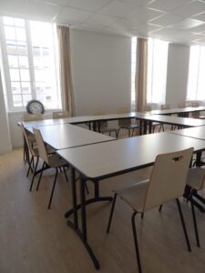 aménagement d'espaces et agencement de mobilier pour le Collegium de Bayeux : table de réunion, chaises empilables, sièges de conférence, canapé lounge, bar central