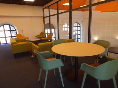 aménagement d'espaces et agencement de mobilier pour le Collegium de Bayeux : table de réunion, chaises empilables, sièges de conférence, canapé lounge, bar central