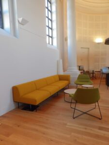 aménagement d'espaces et agencement de mobilier pour le Collegium de Bayeux : table de réunion, chaises empilables, sièges de conférence, canapé lounge, bar central