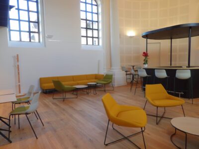 aménagement d'espaces et agencement de mobilier pour le Collegium de Bayeux : table de réunion, chaises empilables, sièges de conférence, canapé lounge, bar central