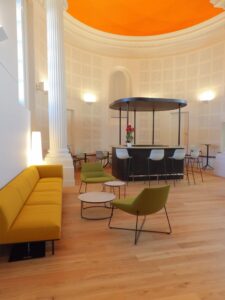 aménagement d'espaces et agencement de mobilier pour le Collegium de Bayeux : table de réunion, chaises empilables, sièges de conférence, canapé lounge, bar central