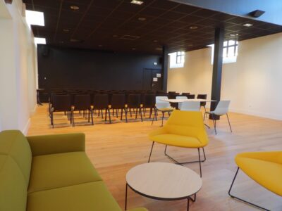 aménagement d'espaces et agencement de mobilier pour le Collegium de Bayeux : table de réunion, chaises empilables, sièges de conférence, canapé lounge, bar central