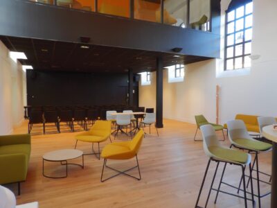 aménagement d'espaces et agencement de mobilier pour le Collegium de Bayeux : table de réunion, chaises empilables, sièges de conférence, canapé lounge, bar central