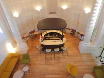 aménagement d'espaces et agencement de mobilier pour le Collegium de Bayeux : table de réunion, chaises empilables, sièges de conférence, canapé lounge, bar central