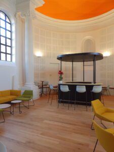 aménagement d'espaces et agencement de mobilier pour le Collegium de Bayeux : table de réunion, chaises empilables, sièges de conférence, canapé lounge, bar central