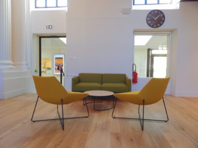 aménagement d'espaces et agencement de mobilier pour le Collegium de Bayeux : table de réunion, chaises empilables, sièges de conférence, canapé lounge, bar central